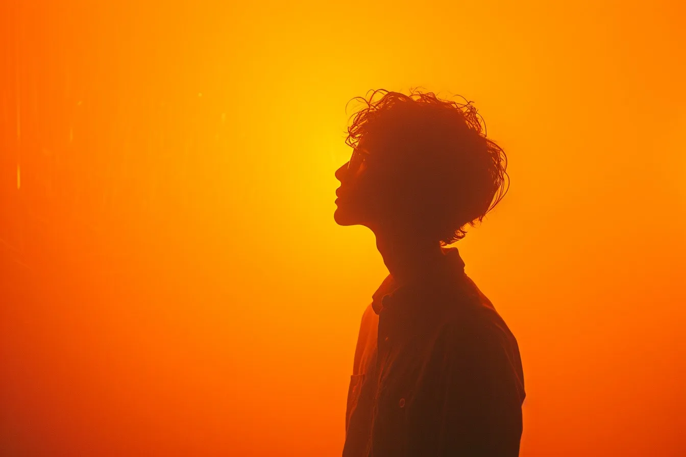 silhouette image of a man who is standing against an orange background
